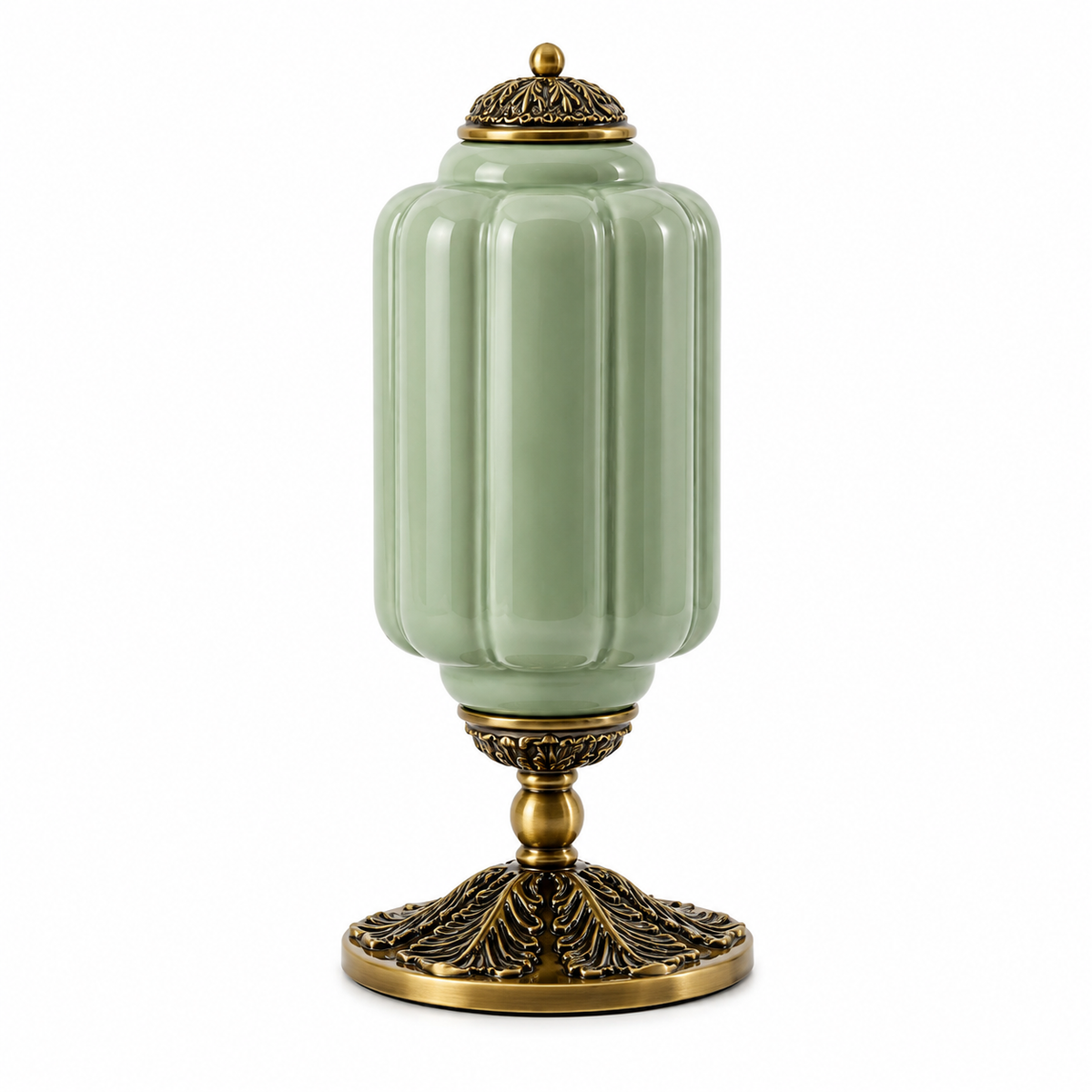 A decorative ceramic table lamp with a pale sage green ribbed body and ornate antique gold metal base and lid, shown on a plain white background.