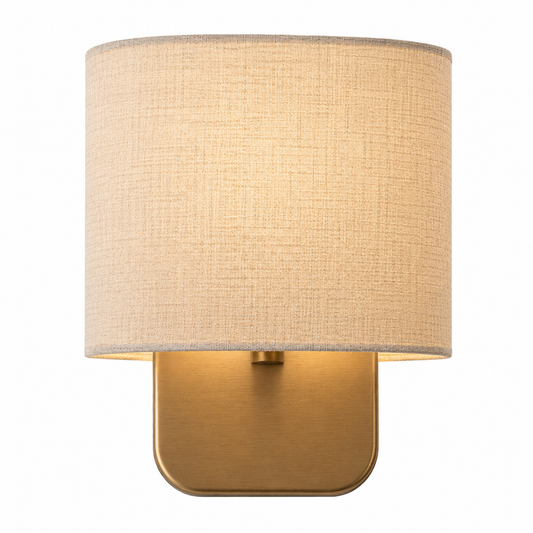 A modern wall sconce with a cylindrical beige linen-textured shade and a square-shaped brushed brass metal base, shown against a plain white background.