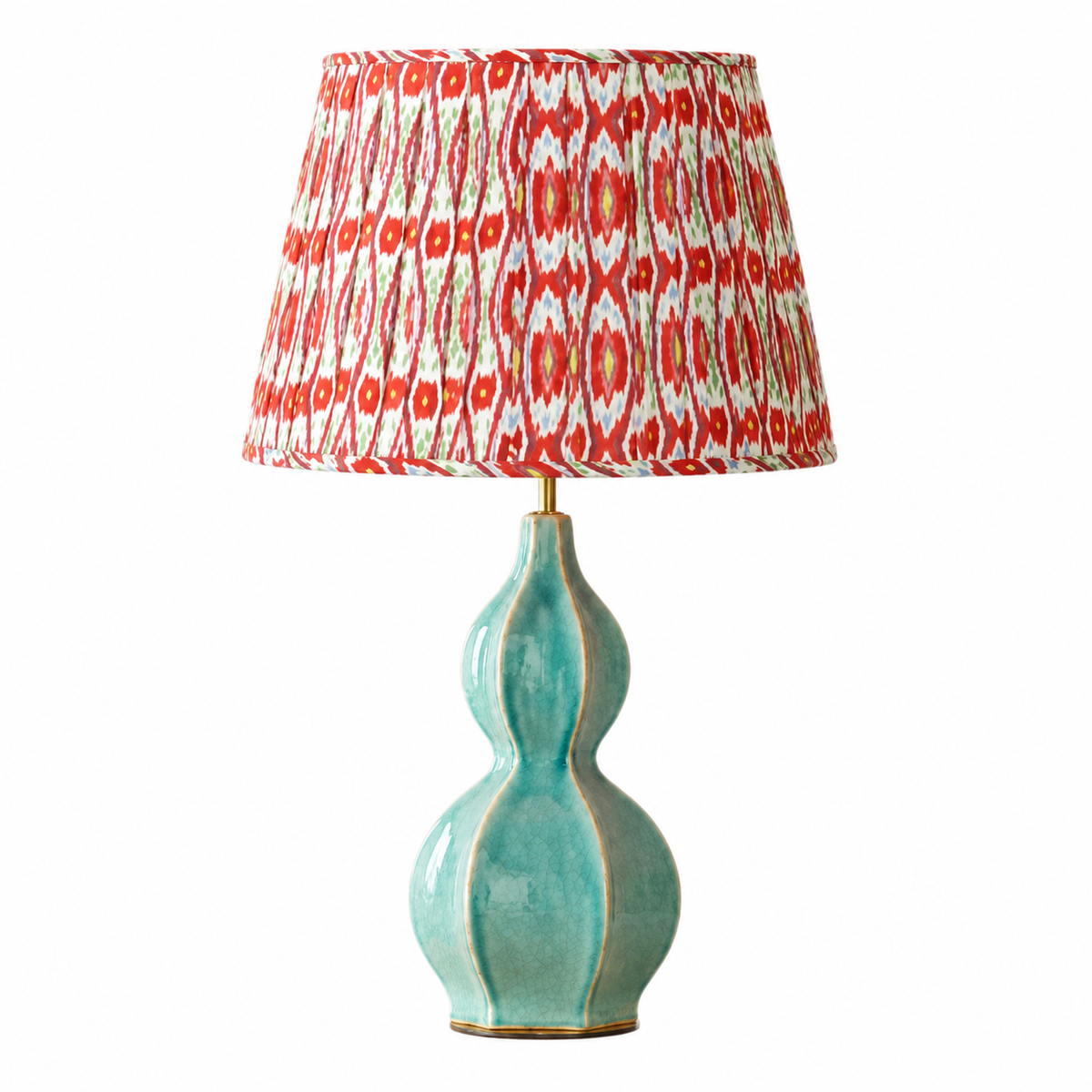 A table lamp with a glossy turquoise-green ceramic gourd-shaped base and a patterned drum shade featuring red, white, and orange ikat-style motifs, shown on a plain white background.
