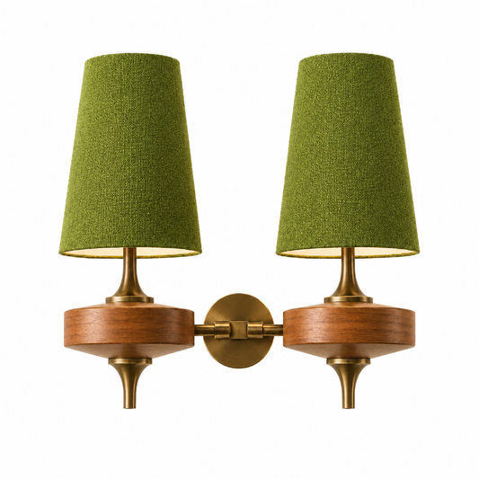 A two-light wall sconce with olive green fabric drum shades, a warm wood midsection, and an antique brass wall mount and hardware, shown against a solid white background.